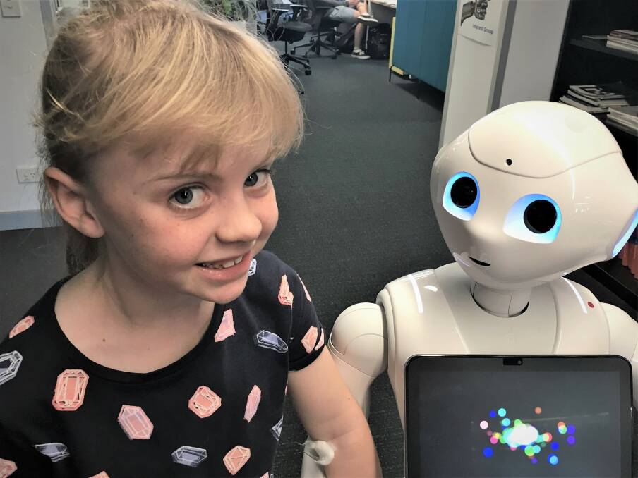 Ella, 7, and Pepper the Robot, at the Australian Centre for Robotic Vision. Photo: Supplied