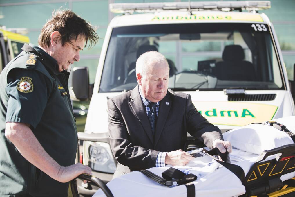 ACT Ambulance Service chief officer Howard Wren and Emergency Services Minister Mick Gentleman inspect one of the new electric stretchers that arrived in the ACT on Monday. Photo: Jamila Toderas