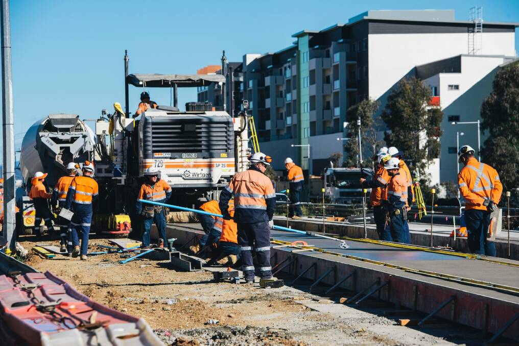 Construction workers laying the light rail concrete slab on Flemington road. Photo: Rohan Thomson