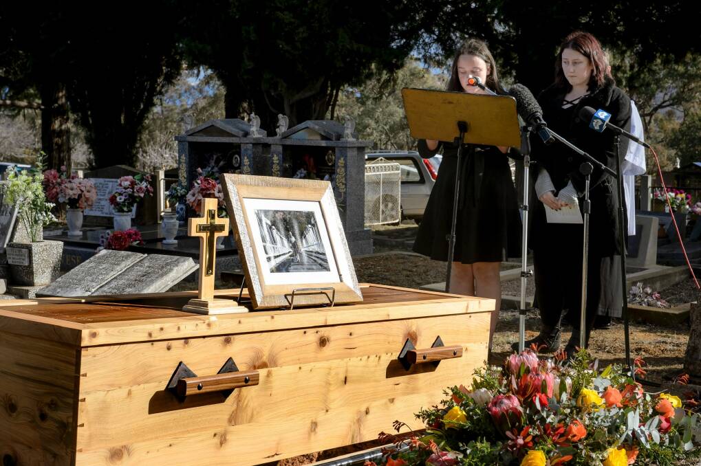 Val Jeffery's grand-daughters Madelaine and Charlotte give a reading at his funeral. Mr Jeffery's coffin was made by Tharwa furniture maker Myles Gostelow, with the metal parts from the original Tharwa bridge.  Photo: Sitthixay Ditthavong