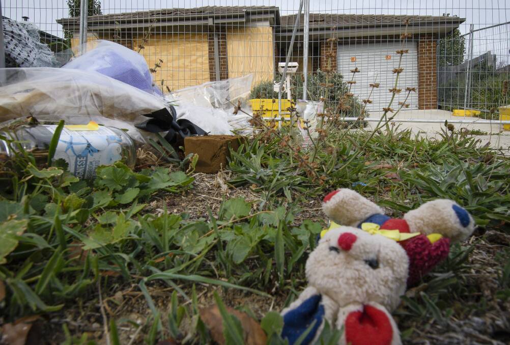 Old flowers and toys outside the scene of a fatal fire on Peter Coppin Street in Bonner, which will soon be demolished. Photo: Sitthixay Ditthavong