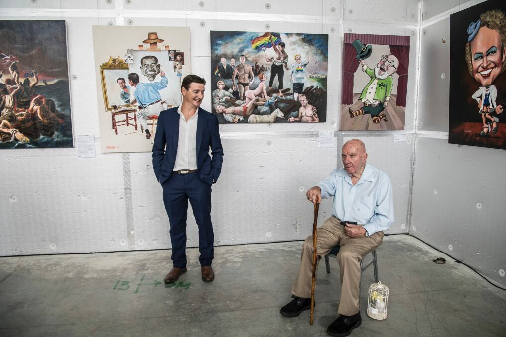 Bald Archy winner James Brennan with his winning painting Anh Can Do (left) and his right another of his paintings 'Penny leading the Way' with Peter Batey, the founding creator of the Bald Archy Prize. Photo: Louise Kennerley