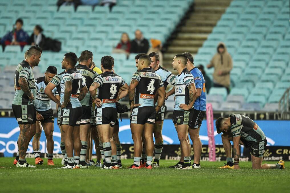 Beaten favourites: Sharks players show their dejection after conceding a try on full-time. Photo: Brett Hemmings
