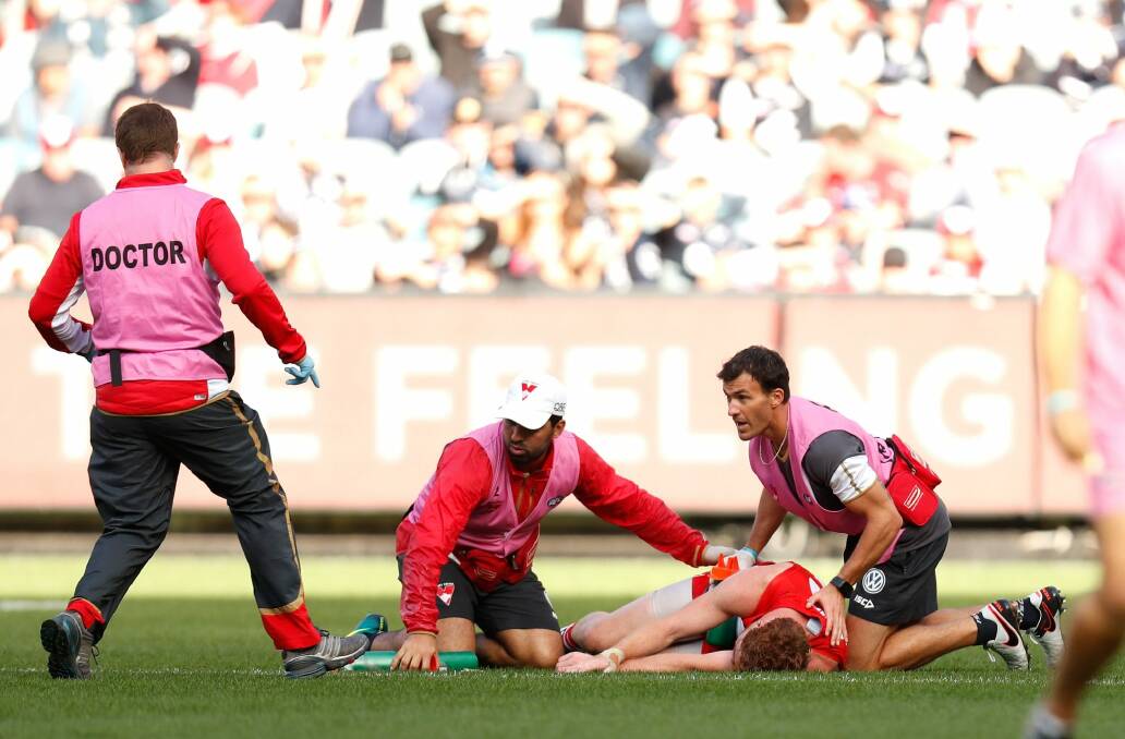 Gary Rohan of the Swans lies injured at the MCG after a collision with Blues defender Sam Rowe.  Photo: AFL Media/Getty Images