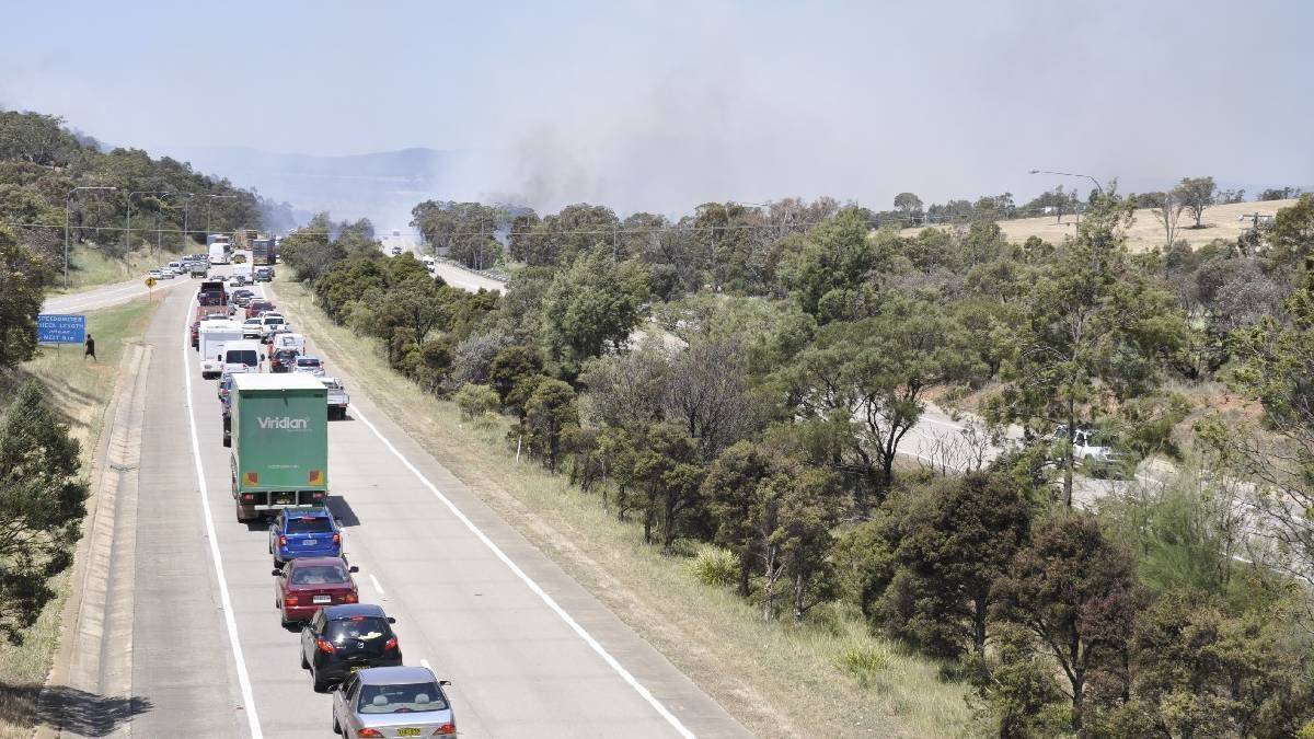 Smoke shrouds the Hume Highway at Goulburn as a grass fire burns out of control. Photo: Louise Thrower, Goulburn Post