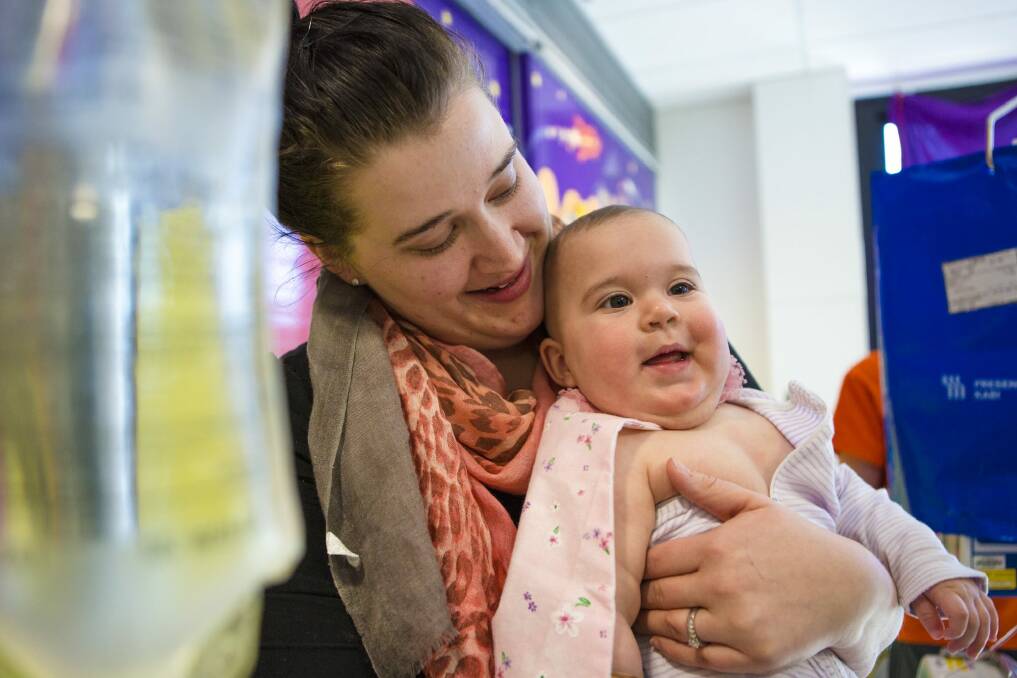 Tjanara Nageeb, and her daughter Eva, 10 months, at the launch of Capes 4 Kids at the Canberra Children's Hospital. Photo: Jamila Toderas