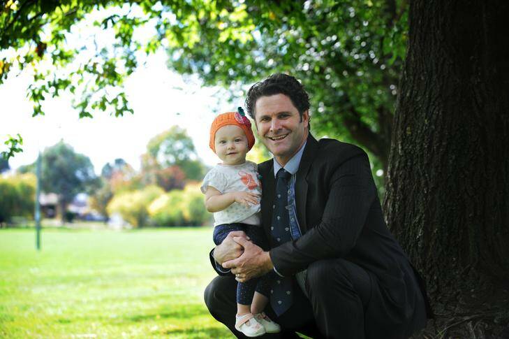 Chris Cairns with his daughter Isabel. Isabel has just received a cochlear implant and can now hear for the first time. Photo: Katherine Griffiths