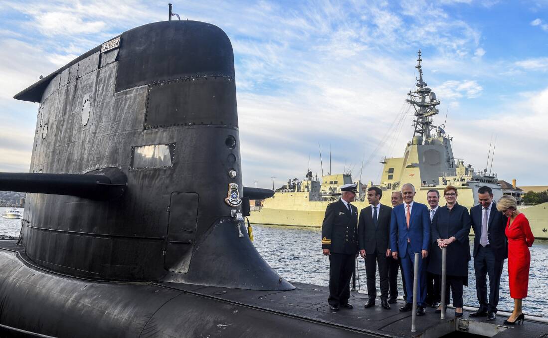 French President Emmanuel Macron, second left, and Prime Minister Malcolm Turnbull, centre, stand on the submarine HMAS Waller on Thursday. Photo: AAP