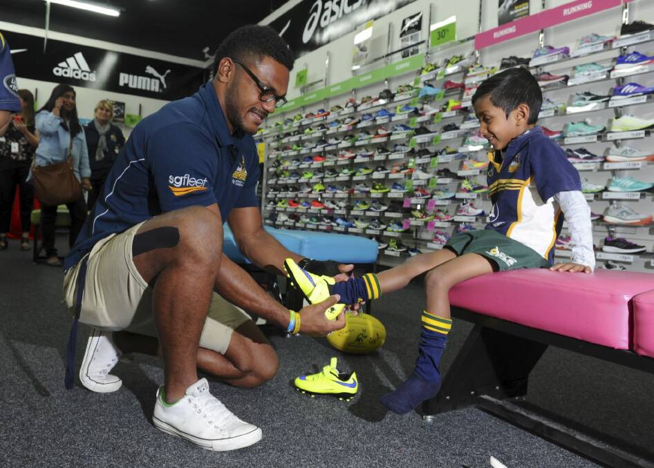 Henry Speight helps fit boots for six-year-old Aminda Weerasooriya of
O'Connor. Photo: Graham Tidy