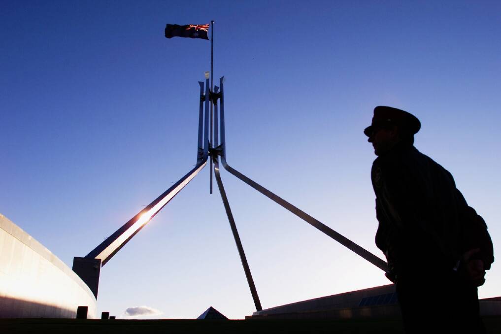 A Parliament House security officer keeps a watchful eye on the roof of Parliament House in Canberra. Photo: Sean Davey