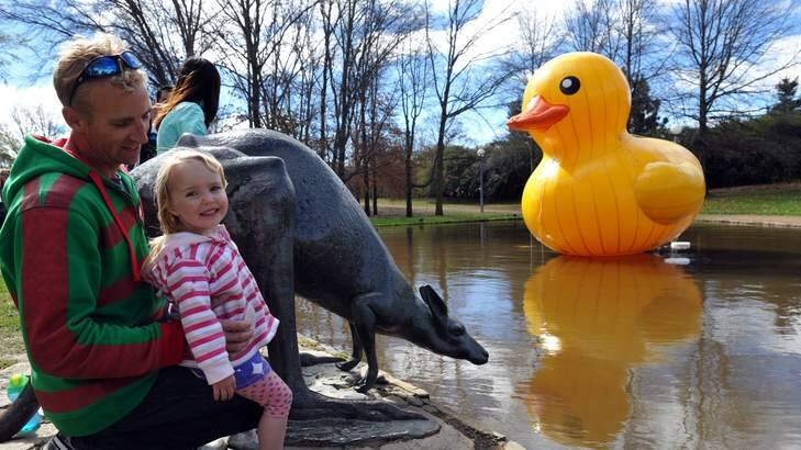 Visitors from Batemans Bay, Justin Lake and his 3 year old daughter, Mia Lake, check out the Floriade yellow duck. Photo: Graham Tidy
