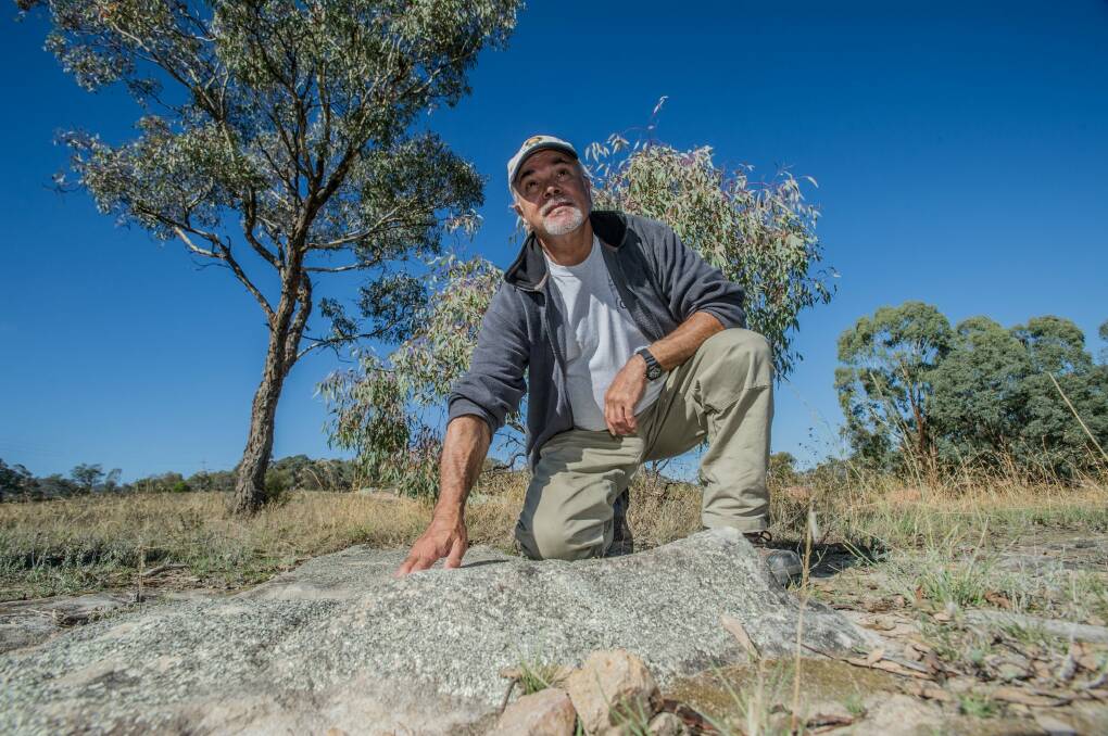 The ACT's first Aboriginal Green Army have begun work across the capital doing land management and cultural learning with Ngunawal elders such as Wally Bell. Pictured at the Theodore grinding rocks. Photo by Karleen Minney. Photo: karleen minney