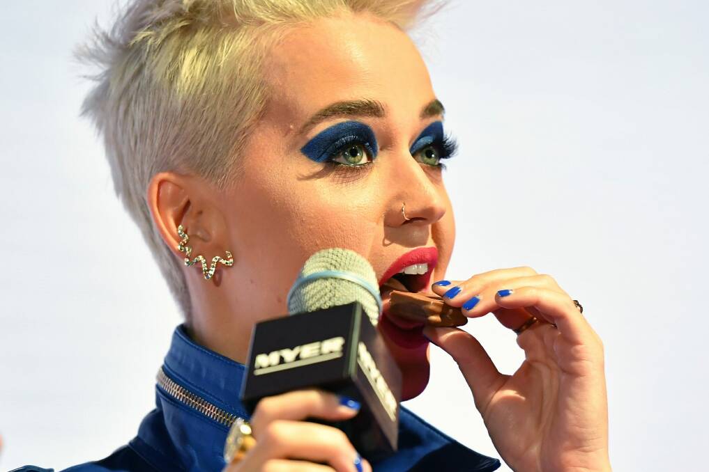 Katy Perry enjoys a Tim Tam during her promo visit to Australia. Photo: Joel Carrett