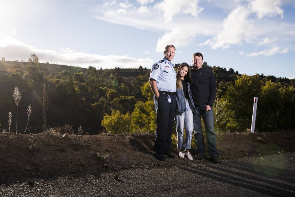 First responders ACT Policing search and rescue coordinator Lachlan Ryan and former ACT Parks area manager Tim Chaseling with Kathleen Bautista at the site of the crash. Photo: Dion Georgopoulos