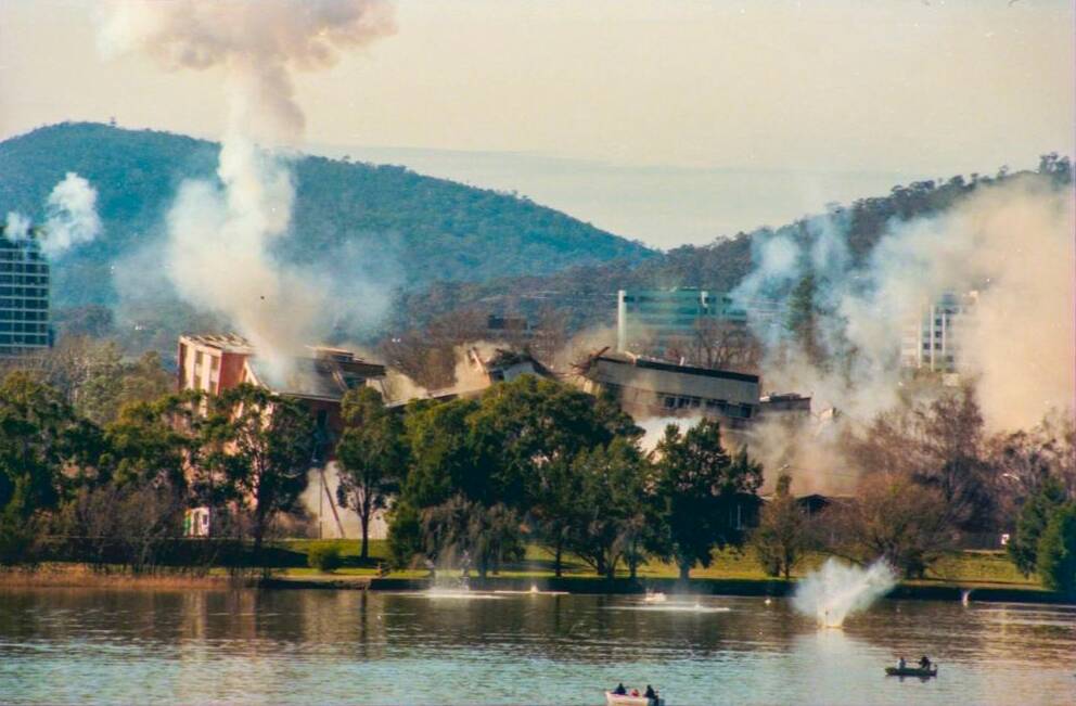 The implosion of the Royal Canberra Hospital as captured by a Canberra Times' photographer, showing debris hitting the water. Photo: Graham Tidy