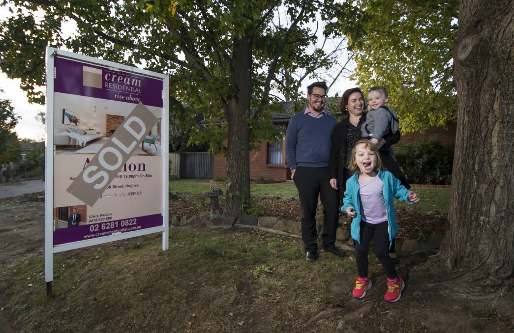 James Giggacher and his family Evie,4 and Finn, 2 and Carla Morgan in front of their million dollar home in Hughes.  Photo: Elesa Kurtz