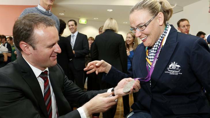 Chief Minister Andrew Barr has a look at Louise Ellery's silver medal that she won at the London Paralympics. Picture: Jeffrey Chan