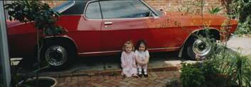 Musician Mark Seymour's daughters with his red Holden Monaro.