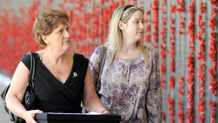 Avril Clark (left) carries a box of petitions as she walks past the Roll of Honour with Sarah McCarthy at the Australian War Memorial. Photo: Alan Porritt