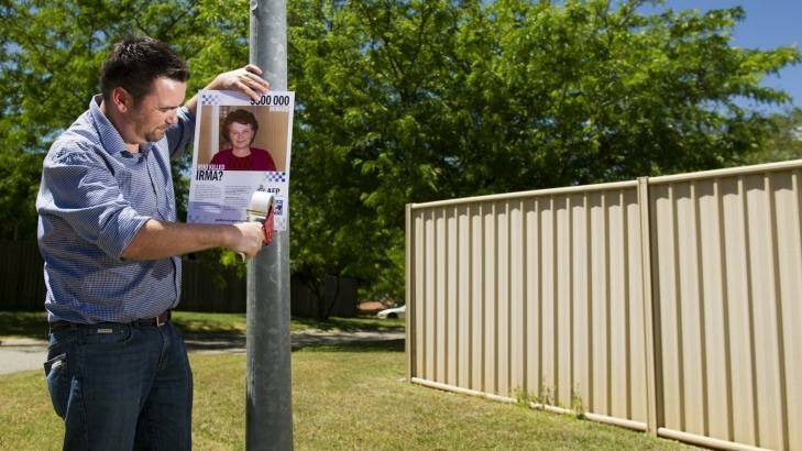 Plea for help: John Mikita puts up posters close to the McKellar home in which his grandmother Irma Palasics was murdered 15 years ago. Photo: Jay Cronan