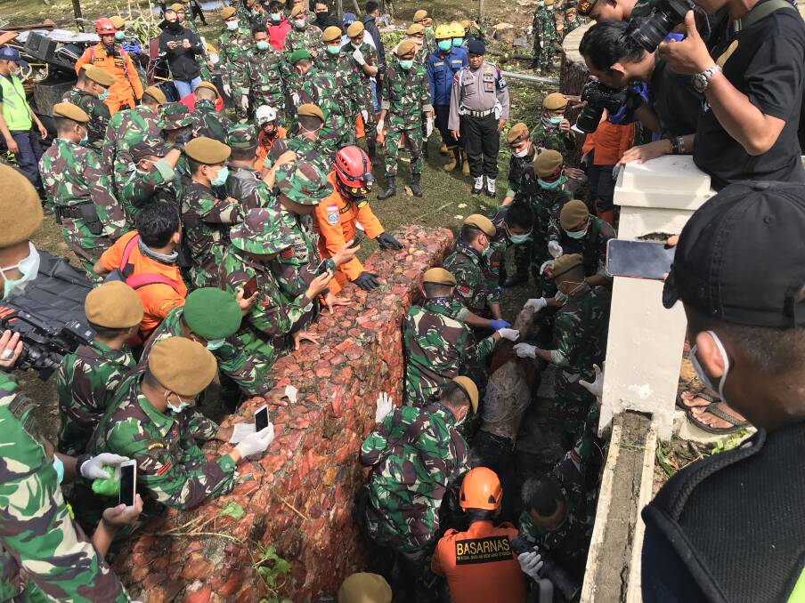 Rescue workers pull a body out of a small cellar, underneath the Tanjung Lesung beach resort’s pool. Photo: James Massola