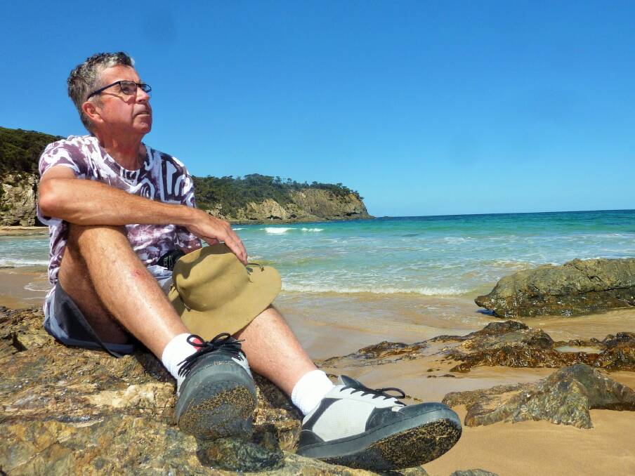 Richard Fisher contemplates the plight of the Dureenbee, wrecked off this south coast beach following a Japanese submarine attack in 1942. Photo: Tim the Yowie Man