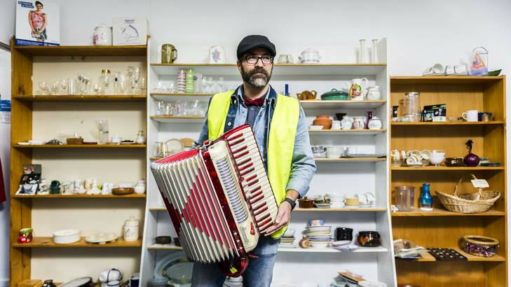 Vinnies Mitchell warehouse manager, Gary Crowder, with a donated piano accordion on the final day of the Vinnies Monster Warehouse Sale. Photo: Rohan Thomson