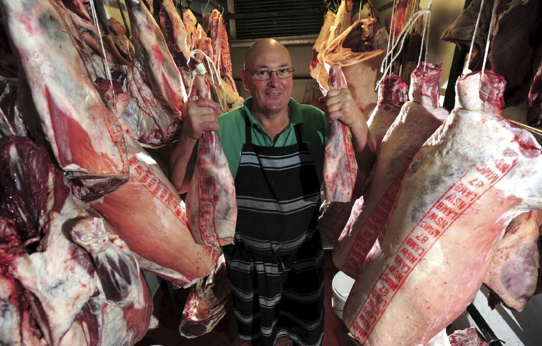 Queanbeyan butcher Peter Linbeck in the cold storage room with lamb trunks and legs. Photo: Graham Tidy