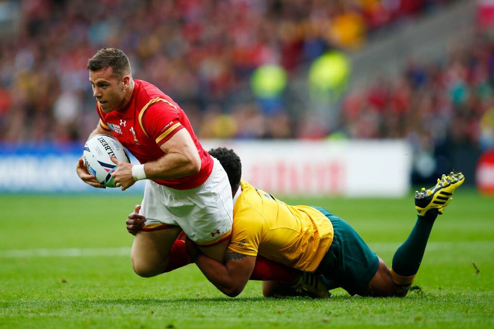 Around the legs: Gareth Davies is tackled by Will Genia. Photo: Mike Hewitt