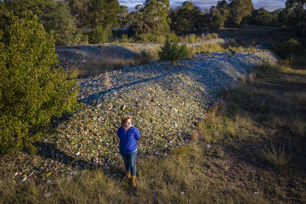 Caitlin Miller with about 900 tonnes of glass she says was dumped on her Bywong property by her father, Garry Miller, without permission.  Photo: Sitthixay Ditthavong