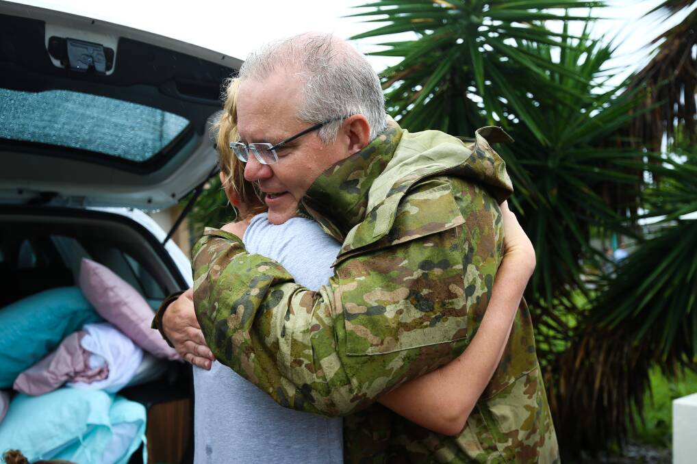 Mr Morrison is seen hugging a Townsville resident. Photo: AAP Image/Dave Acree