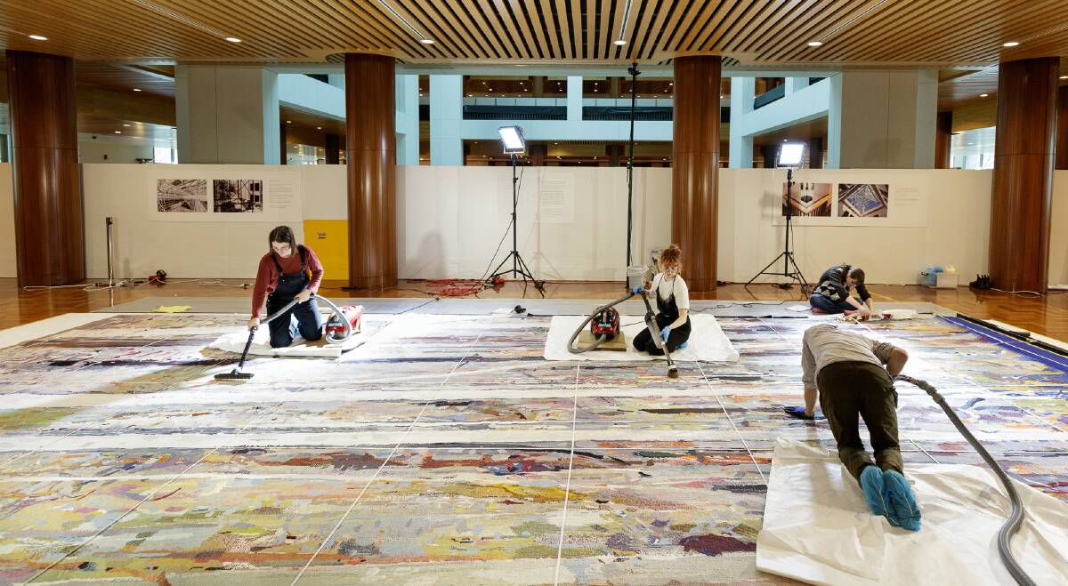 Conservation and heritage students at the University of Canberra got hands-on experience vacuuming the sprawling tapestry. Photo: Parliament House Art Collection