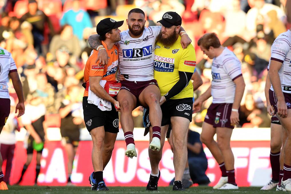 Casualty: Dylan Walker is carried from the field after appearing to injure his knee. Photo: AAP