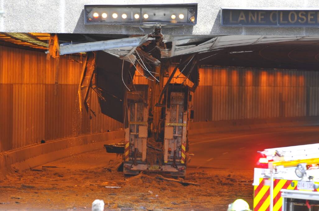 An excavator on the back of a low loader ripped 60m of tiles from the ceiling of the Parkes Way tunnel. Photo: Jay Cronan