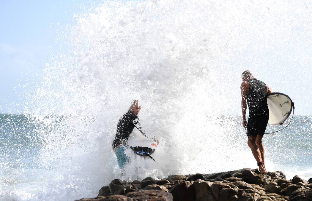 Surfers getting smashed by the big swell and high tides at Noosa on the Sunshine Coast on Friday. Photo: Dan Peled - AAP