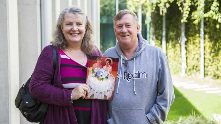 Julia and Barry Rollings at the Legislative Assembly on Thursday with a photo of their daughter's wedding in the US. Photo: Rohan Thomson