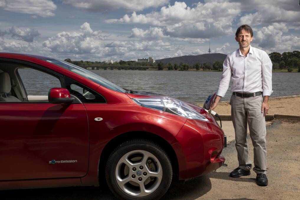Denby Angus with his electric car, the Nissan Leaf, which was imported from overseas. Photo: Sitthixay Ditthavong