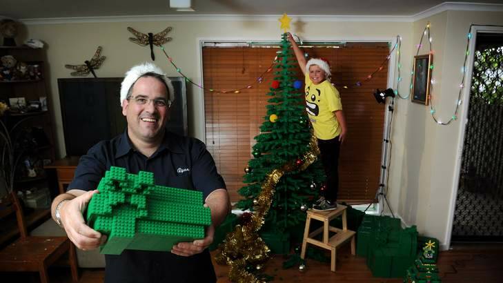 Oliver McLauchlan, 9, with the 2m by 1.5m LEGO tree that Ryan McNaught, left, built. Photo: Colleen Petch