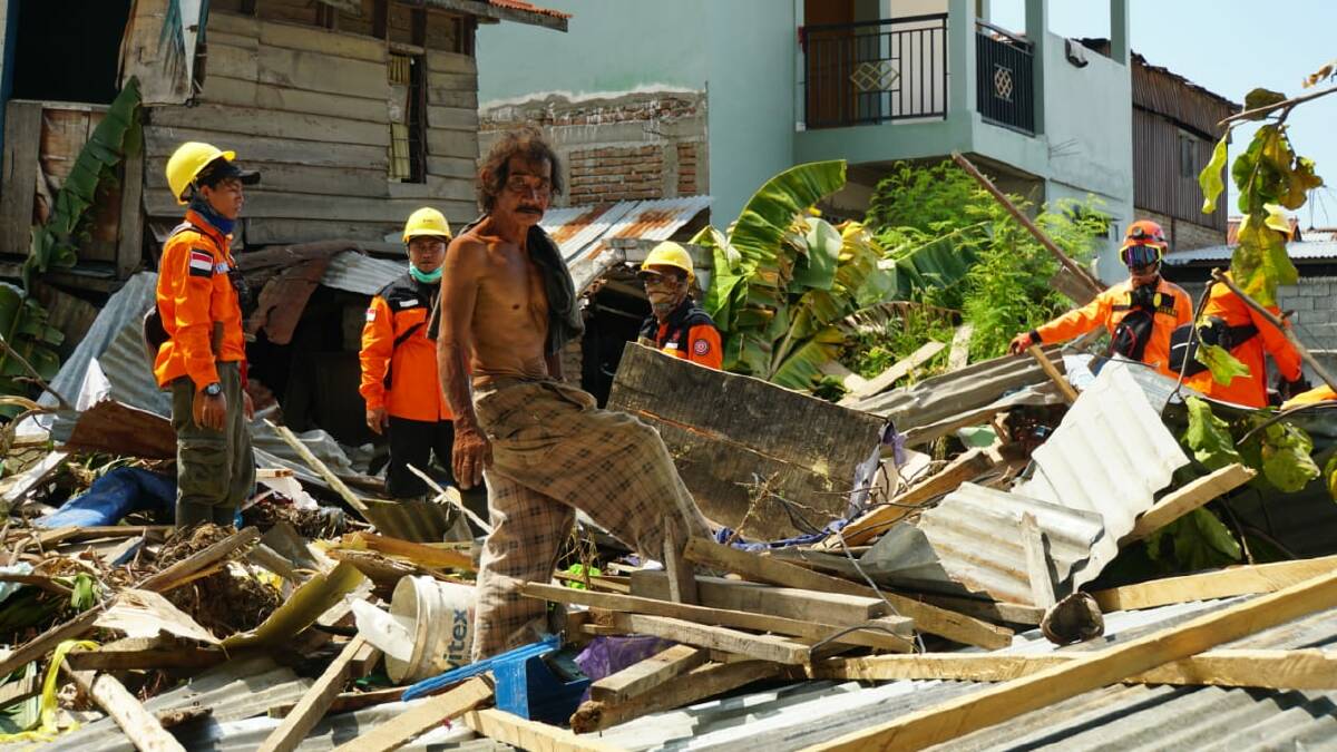 Daeng Fajar, centre, with an evacuation team looks for the young daughter of a street seller in the rubble at Talise, Palu, Sulawesi.. "We are not blood related, but she's family." Photo: Amilia Rosa