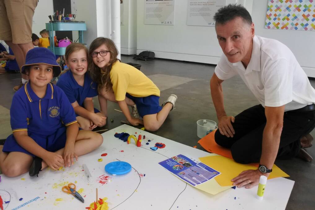 Students from Giralang Primary School teamed up with graphic design students at the University of Canberra to create a report card aimed at curbing childhood obesity. University of Canberra professor of public health Tom Cochran is with some of the students in an art and craft workshop encouraging healthy lifestyles. Photo: Clare Sibthorpe