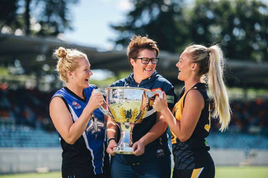 Women's ACT AFL players Britt Tully and Ella Ross with Adelaide coach Bec Goddard and the 2017 premiership cup. Photo: Rohan Thomson