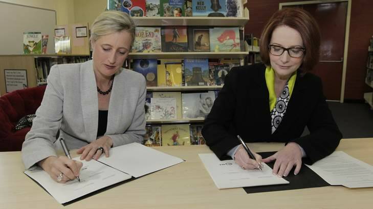 Prime Minister Julia Gillard signs the Gonski school funding agreement with ACT Chief Minister Katy Gallagher at Lyneham High School in Canberra on Thursday. Photo: Andrew Meares