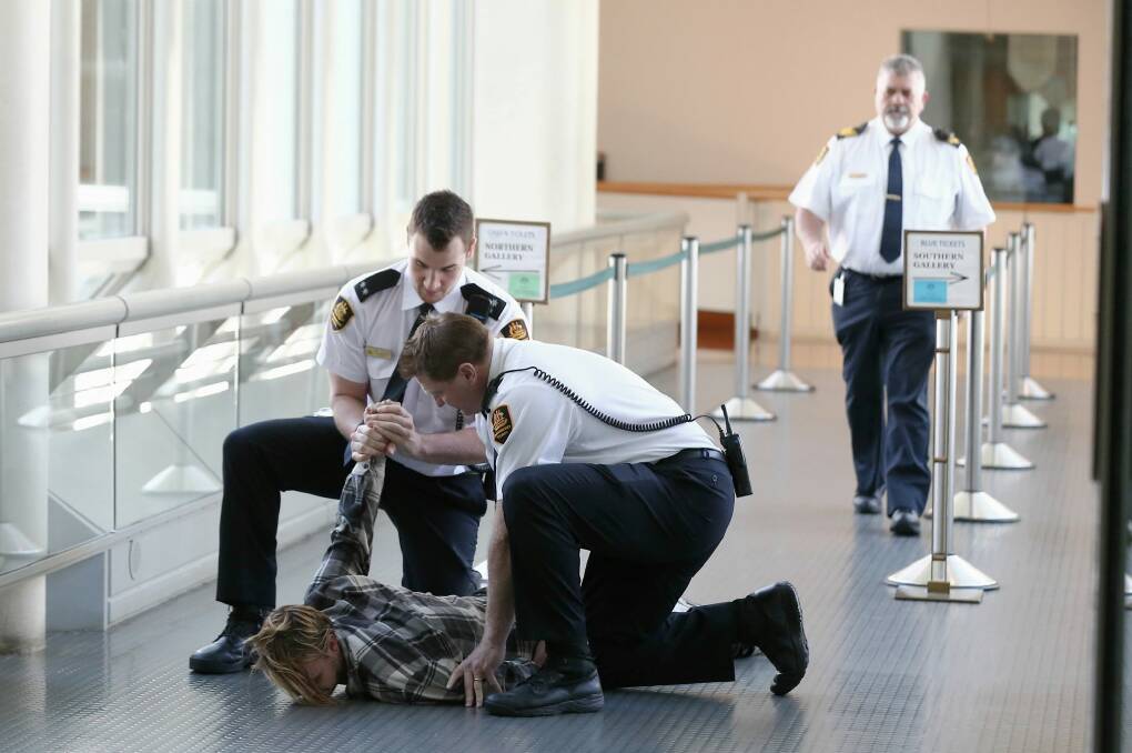 Security guards drag a man out of the House of Representatives. Photo: Alex Ellinghausen