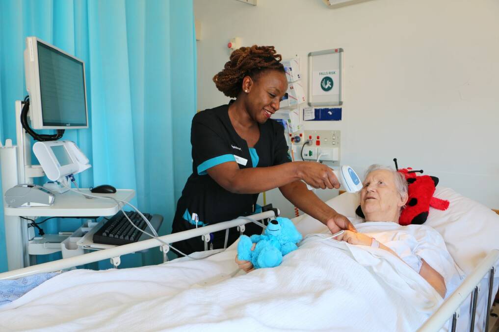 At the Canberra Hospital, nurse Gladys Kamale uses the PPID system with patient Audrey Vanderburgh. Photo: Supplied/ ACT Health
