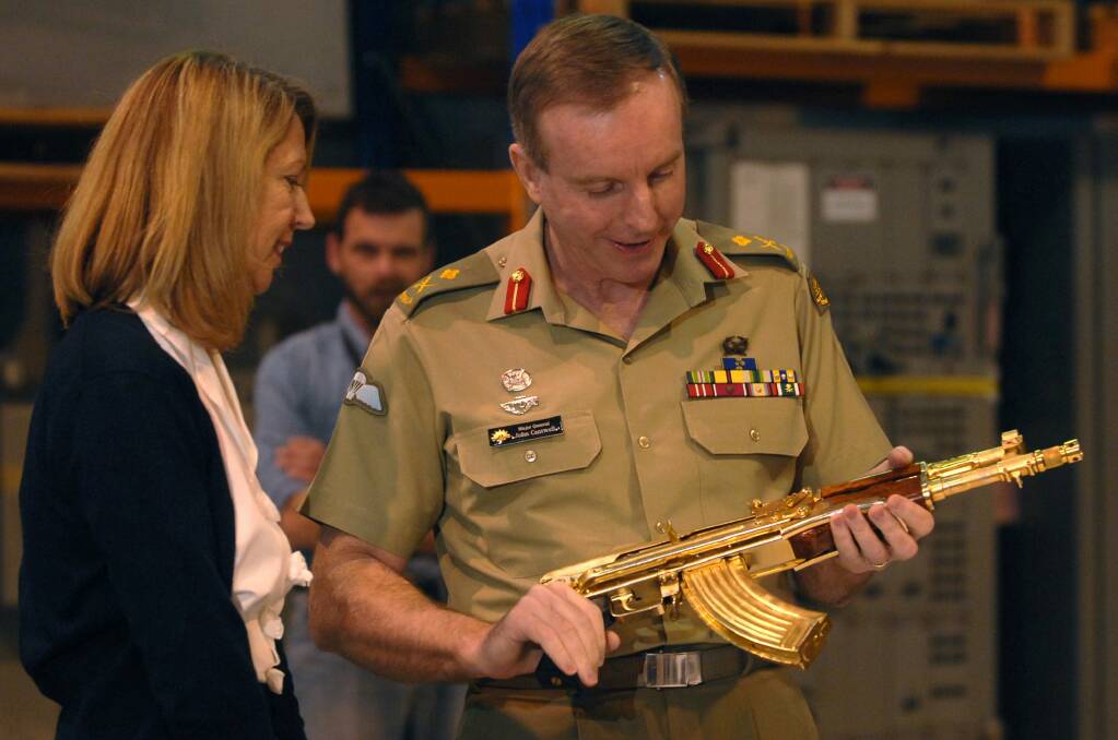 Major-General John Cantwell hands the gold-plated assault rifle to then War Memorial executive Nola Anderson in 2007. Photo: Graham Tidy