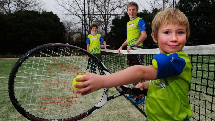 Junior tennis players Owen Bamford, 5, front, with his brothers Griffin, 11, left, and Lachlan, 13, all of Barton at the Reid Tennis Club, Canberra. Photo: Melissa Adams