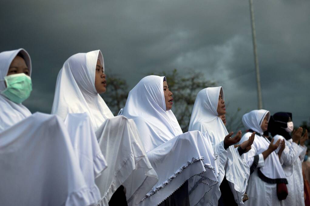 Indonesian women attend a prayer for the victims of the September 28 earthquake and tsunami on Talise Beach in Palu, Central Sulawesi, Indonesia, on Friday. Photo: AP