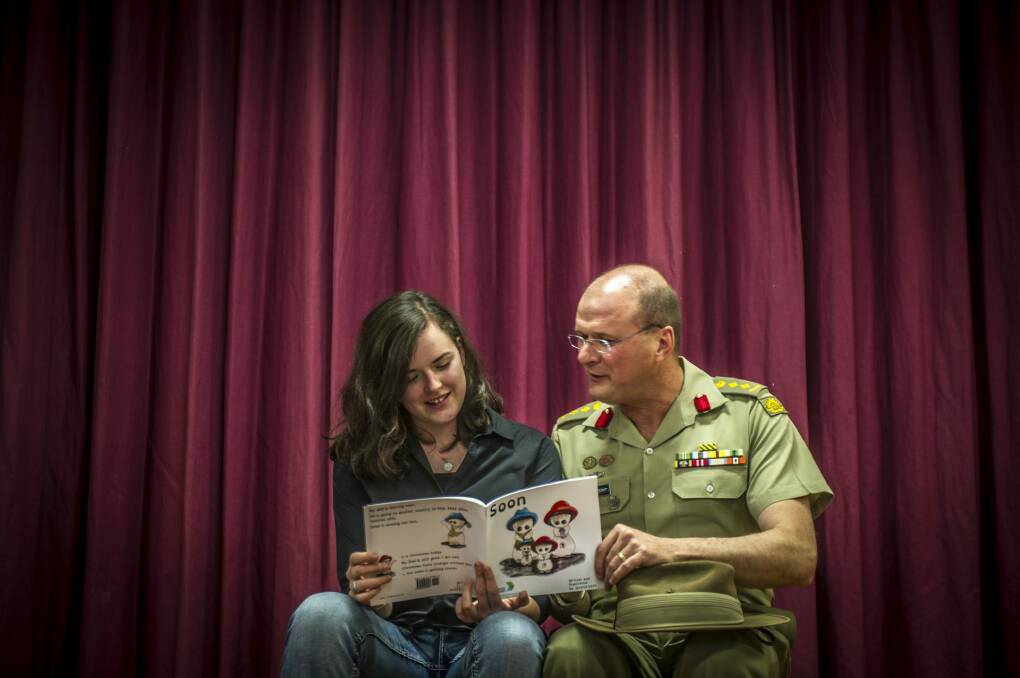 Teen author Jessica Love and her father, Australian Army Colonel Shaun Love, look at her book addressing parental deployment through a child's eyes. Photo: Karleen Minney