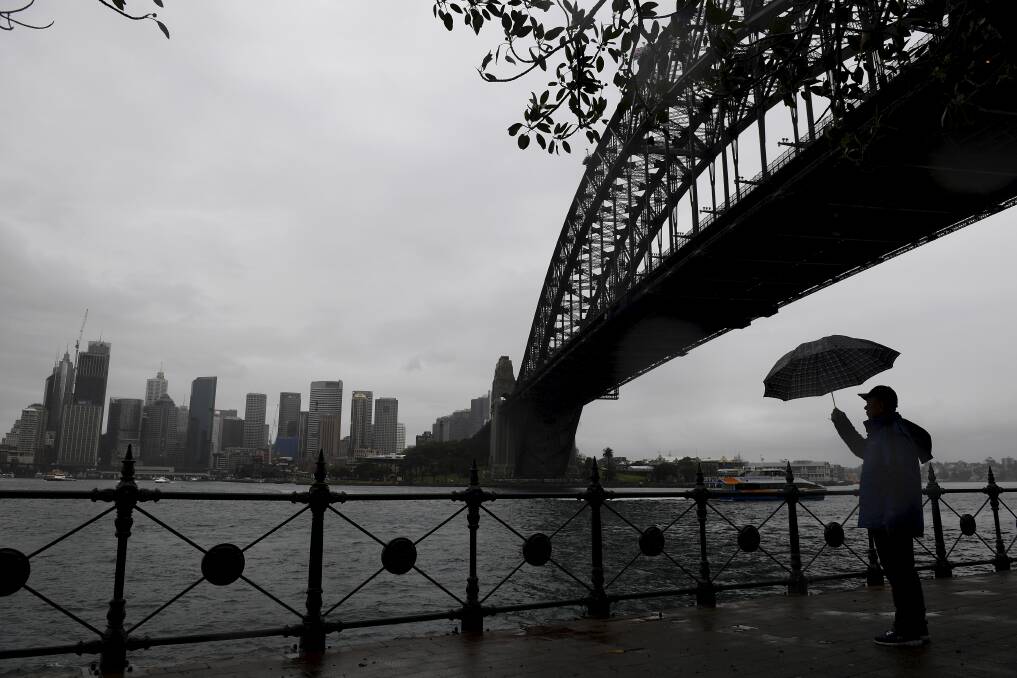 A tourist is seen as rain continues to fall in Sydney. Photo: Dan Himbrechts