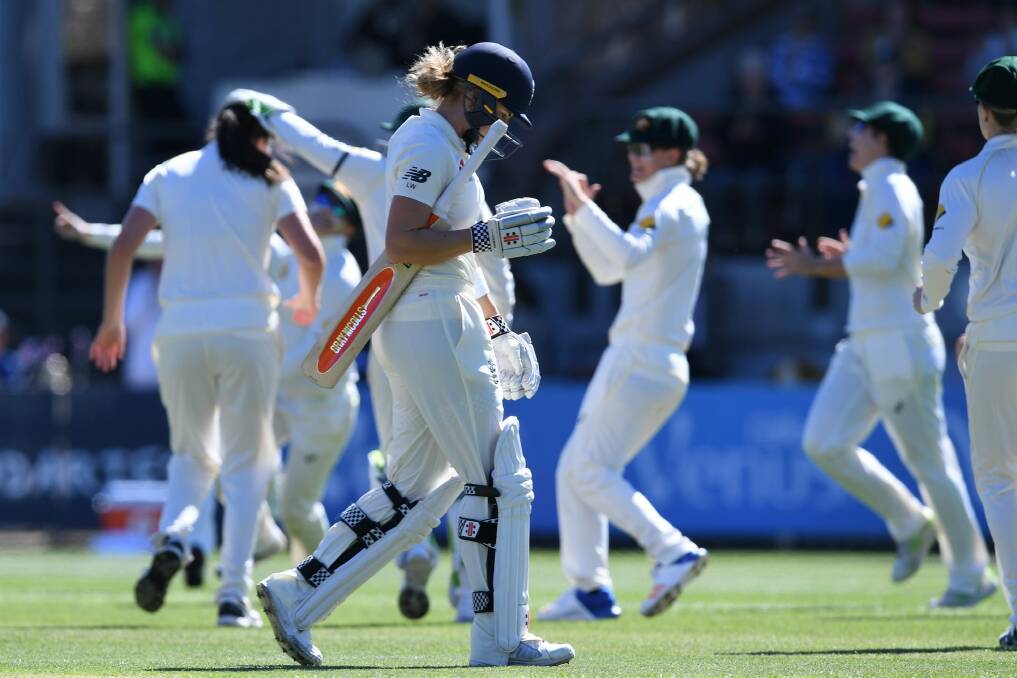 Dismissed for just four runs off 56 balls: England's Lauren Winfield walks from the pitch as the Australian team celebrates. Photo: AAP